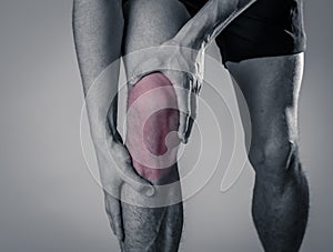 Sport man injured when exercising or running holding his knee in pain