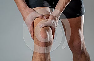 Sport man injured when exercising or running holding his knee in pain