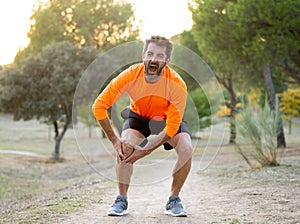 Sport man injured when exercising or running holding his knee screaming in pain