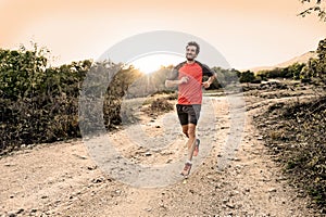 Sport man with ripped athletic and muscular legs running downhill off road in jogging training workout
