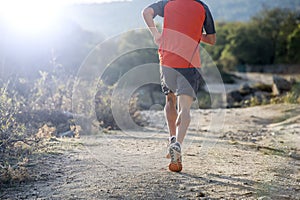 Sport man with ripped athletic and muscular legs running uphill