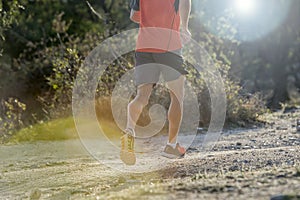 Sport man with ripped athletic and muscular legs running uphill