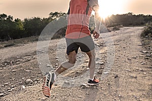 Sport man with ripped athletic and muscular legs running uphill off road in jogging training workout