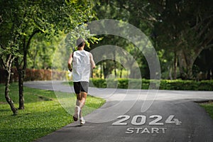 Sport man running at park garden. Start into the new year 2024. Start up of runner woman running on road park nature go to Goal of