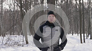 Sport man running in winter city park during morning jog. Jogging in winter forest
