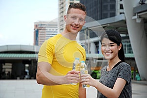 Sport Man and Sport Girl drinking water on street