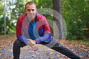 Sport man stretching at the park autumn, doing exercises. Fitness concepts