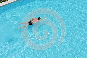 Sport man swimming pool in the resort. on top