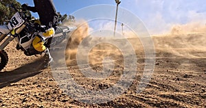 Sport, motorbike and sand for race in desert driving and person with off road stunt on hill. Dirt, trail and fast driver