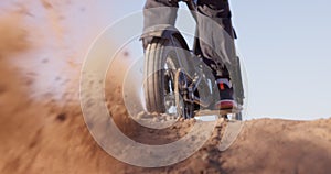 Sport, motorcycle and sand in wheel from desert driving and person with off road stunt on hill. Dirt, trail and fast