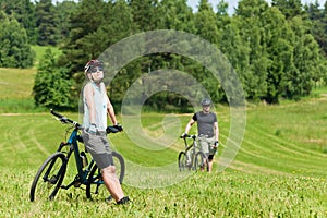 Sport mountain biking couple relax in meadows