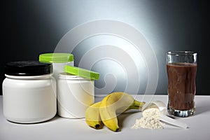 Sport Nutrition Supplement containers with glass of cocktail
