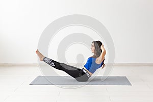 Sport, people concept - young woman swinging press by statics exercises photo