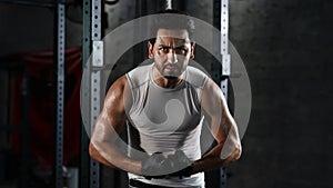 Sport portrait of caucasian athletics strong bodybuilder man posing show his muscle in gym in dark tone