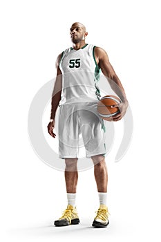 Sport. Professional basketball player standing in white background. Basketball ball. Isolated