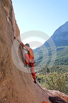 Sport rock climber on challenging climbing route