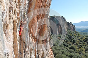 Sport rock climber on challenging climbing route