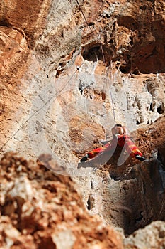 Sport rock climber on challenging climbing route