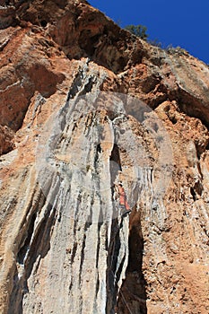 Sport rock climber on challenging climbing route