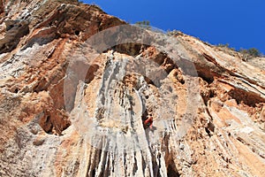 Sport rock climber on challenging climbing route