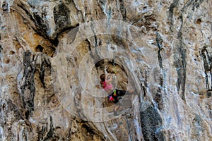 Sport rock climber on challenging climbing route with stalactite in Thailand  Ton Sai