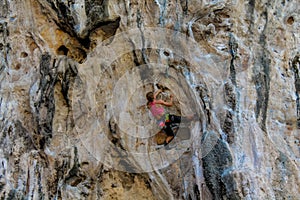 Sport rock climber on challenging climbing route in Ton Sai, Thailand