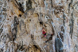 Sport rock climber on challenging climbing route in Ton Sai, Thailand