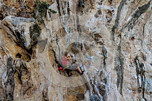 Sport rock climber on challenging climbing route in Ton Sai, Thailand