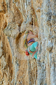 Sport rock climber woman on challenging overhanging climbing route in Kalymnos, Greece