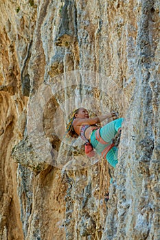 Sport rock climber woman on challenging overhanging climbing route in Kalymnos, Greece