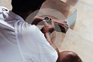 Sport runner black man wear modern time smart watch he sitting resting