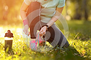 Sport runner woman tying laces before training. Marathon.