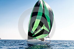 Sport sailing boat with a striped sail