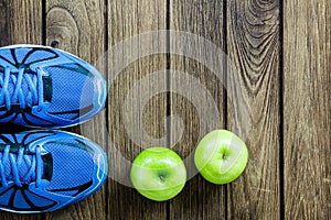 Sport shoes, Apples on a wooden background. Sport