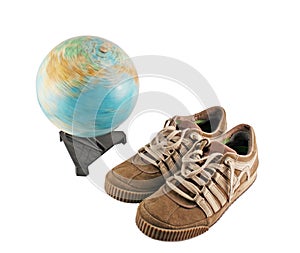 Sport shoes next to a globe