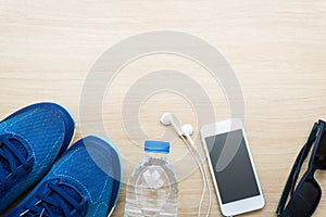 Sport shoes, smart phone, sunglasses and water