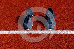 Sport shoes on a start line of racetrack