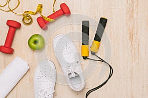 Sport shoes and water with set for activities on wooden floor.