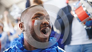 Sport Stadium Big Event: Handsome Black Man Cheering. Crowd of Fans with Painted Faces Shout for