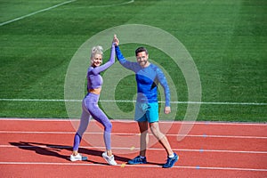 Sport success. male and female coach on stadium running track arena. healthy lifestyle. sport couple celebrate team win