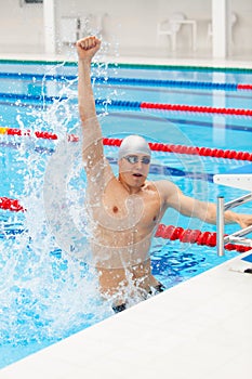 Sport swimmer winning. Man swimming cheering celebrating victory success smiling happy in pool wearing swim goggles and