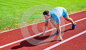 Sport tips from professional runner. Man athlete runner stand low start position stadium path. Make effort for victory