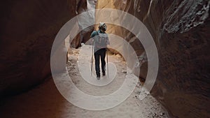 Sport Tourist Man Trekking On Dry Riverbed In Deep Slot Canyon With Orange Rocks