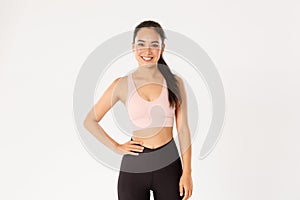 Sport, wellbeing and active lifestyle concept. Cheerful smiling asian girl promote you logo gym, special discount for