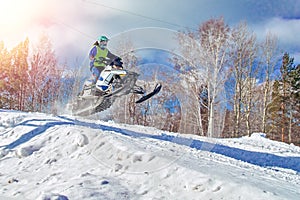 Sport white snowmobile jump. Clear sunny winter day. Extreme sport background for any purposes. Concept quick movement. photo