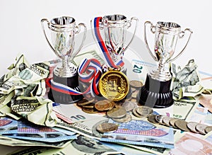 Sport winning concept: three cups among diverse currencies euro, dollar and russian rubls