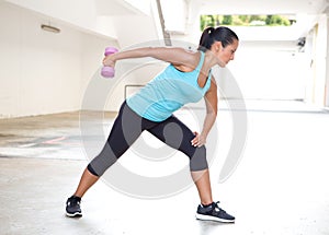 Sport woman in blue with dumbbell doing tricep back extension exercise