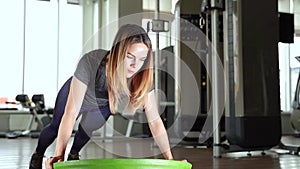 Sport woman doing exercises with a balance ball at gym.