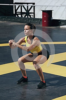 Sport woman doing squat exercise workout at outdoor gym