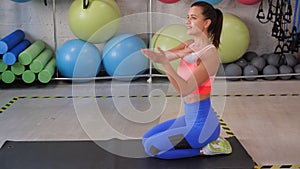 Sport woman doing stretching exercise on carpet before fitness training in gym. Fitness woman warming up before muscles